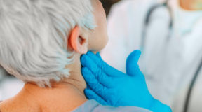 Médico endocrinologista examinando a glândula tireoide de uma senhora