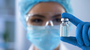 Enfermeira com frasco de medicamento na mão