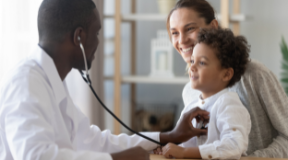 Médico auscultando uma criança na presença da mãe