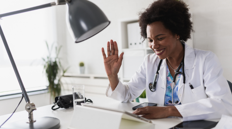Médica sorrindo ao falar em seu celular