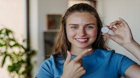 Menina diabética sorrindo mostrando medicamento